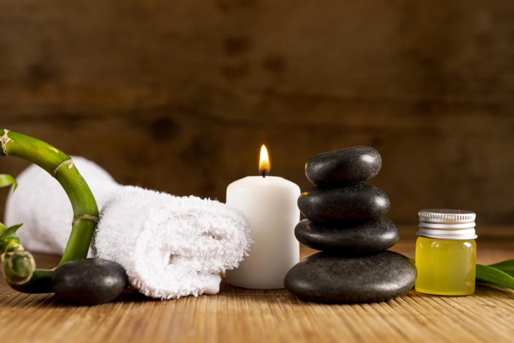 Relaxing spa setup featuring neatly rolled towels, smooth black massage stones, and a serene ambiance, perfect for a rejuvenating massage experience.